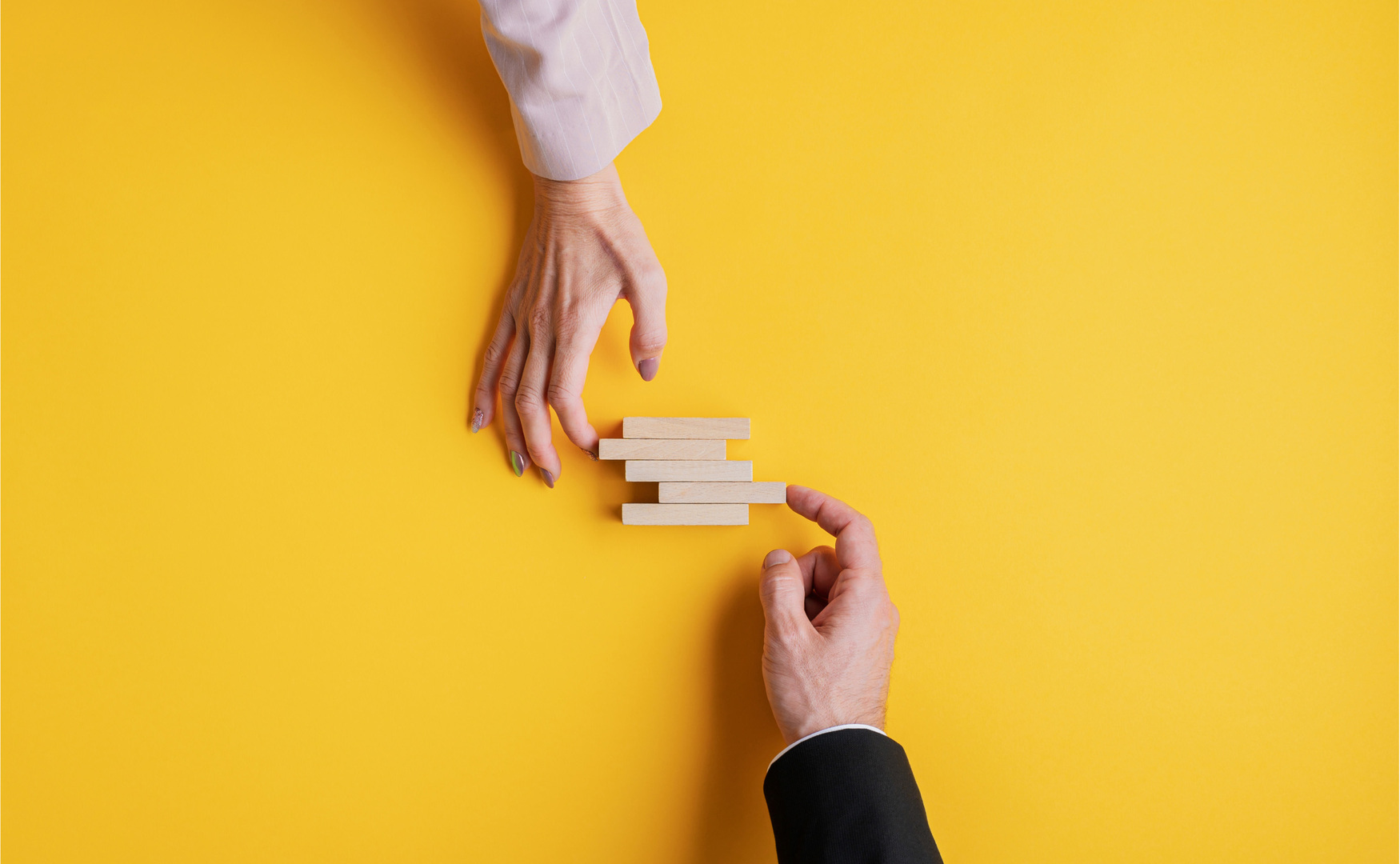manos sobre fondo amarillo